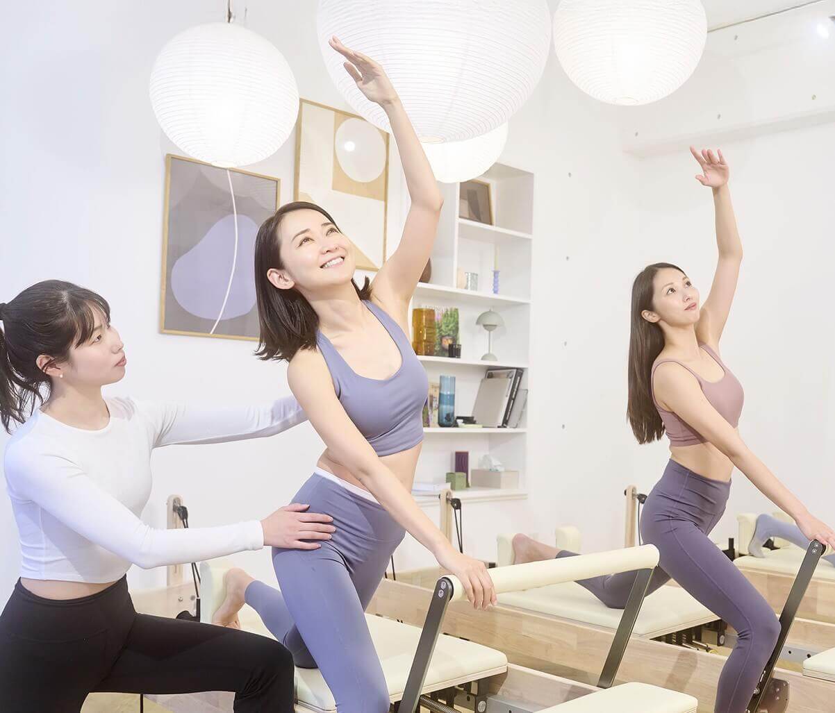 講師にマシンピラティスレッスンを受ける女性会員